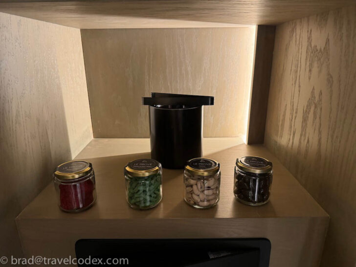 a shelf with jars of food and a black container