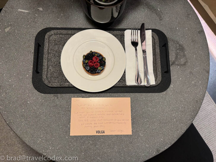 a plate with fruit on it and a fork and knife on a tray