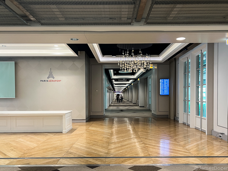 a hallway with a chandelier and a long table