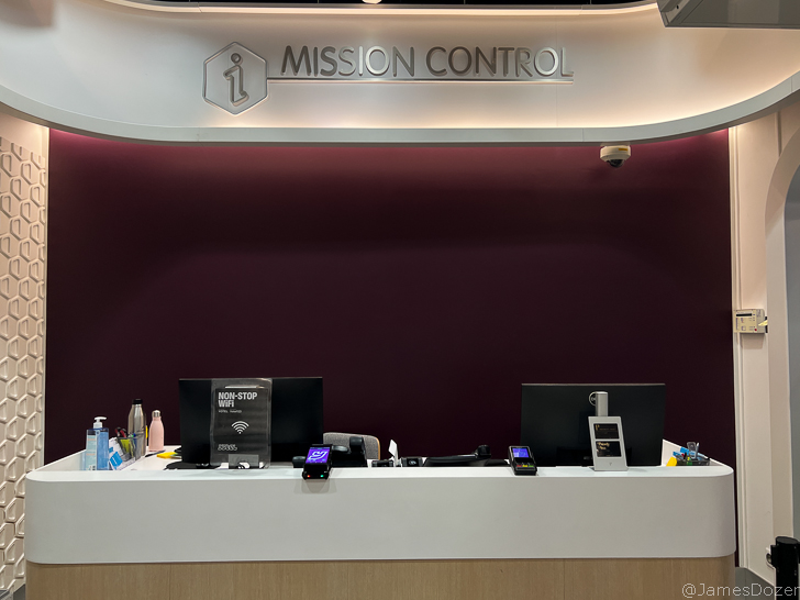 a reception desk with a sign and a bar
