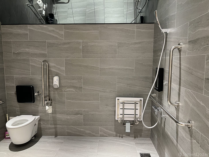 a bathroom with grey tile walls and a toilet