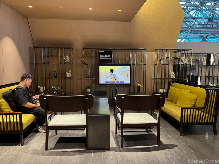 a man sitting on a couch in a room with a television