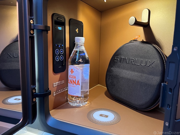 a small black bag and a bottle of water in a small box