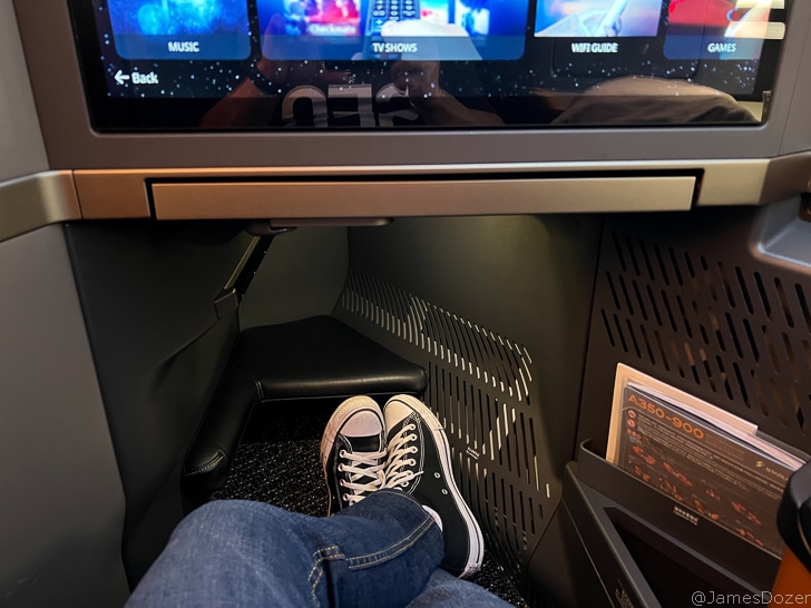 a person's feet in a seat with a television