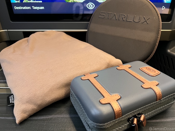 a small case and a pillow next to a television