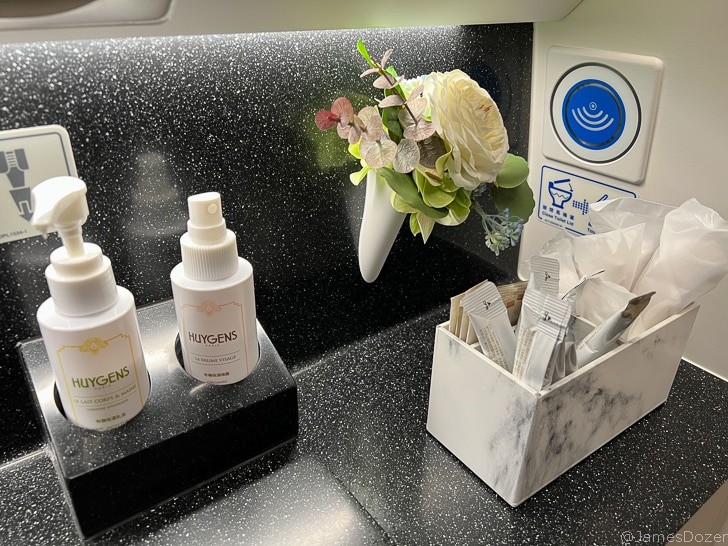 a small white container with a flower and a white container with a white flower