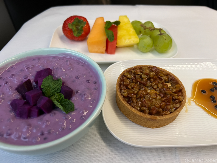 a bowl of purple food and fruit on a plate