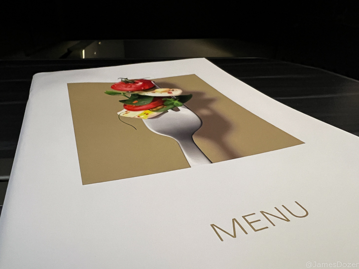 a menu with a fork and food on it
