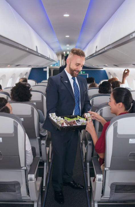 a man in a suit holding a basket of food in a plane