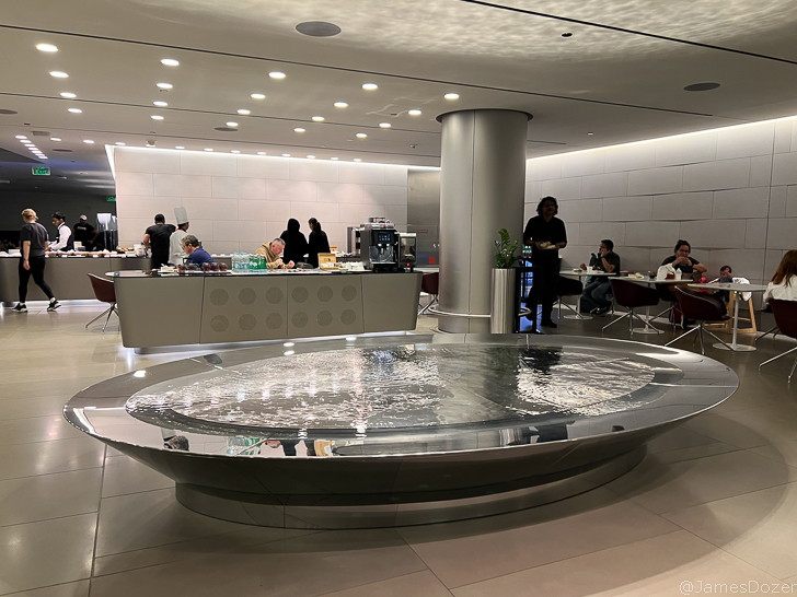a large circular fountain in a room with people around it