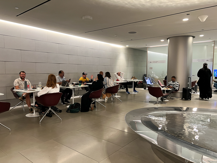 a group of people sitting at tables in a room with a fountain