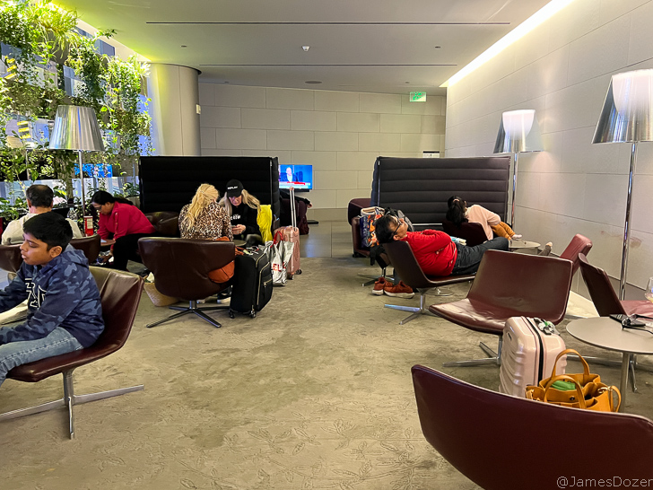 people sitting in chairs in a room with luggage