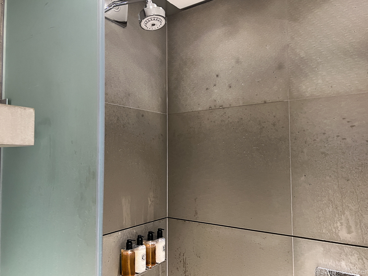 a shower head with a few bottles of liquid on it