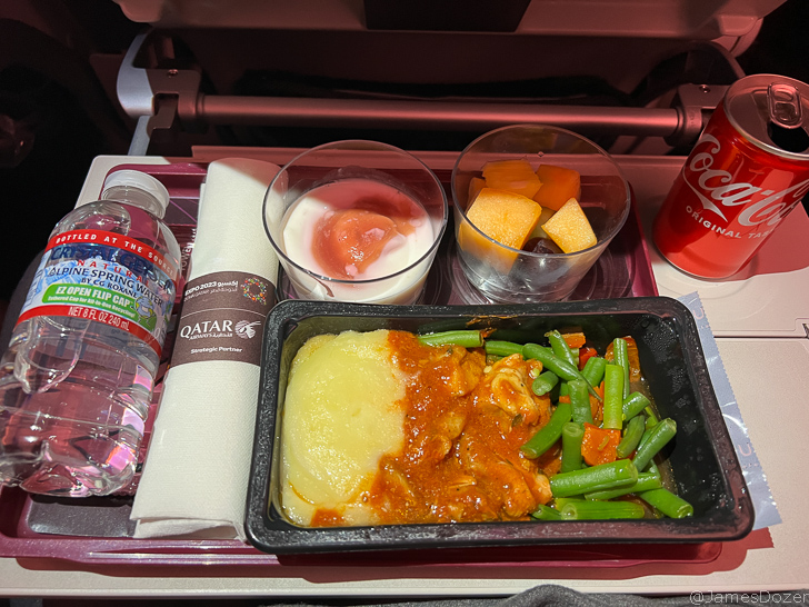 food on a tray with a drink and a bottle of water