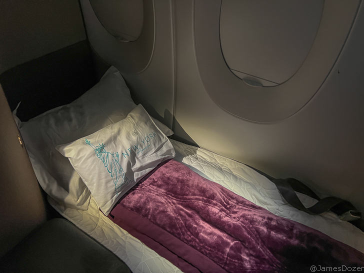 a bed with a pillow and a blanket in a plane