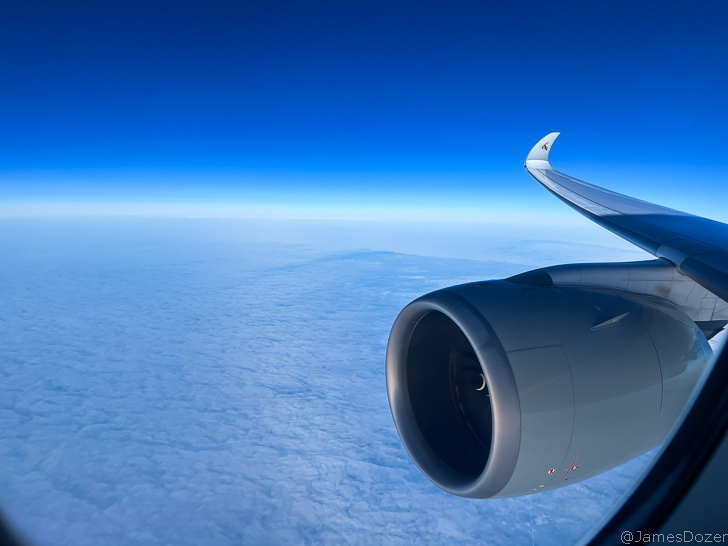 an airplane wing and a blue sky