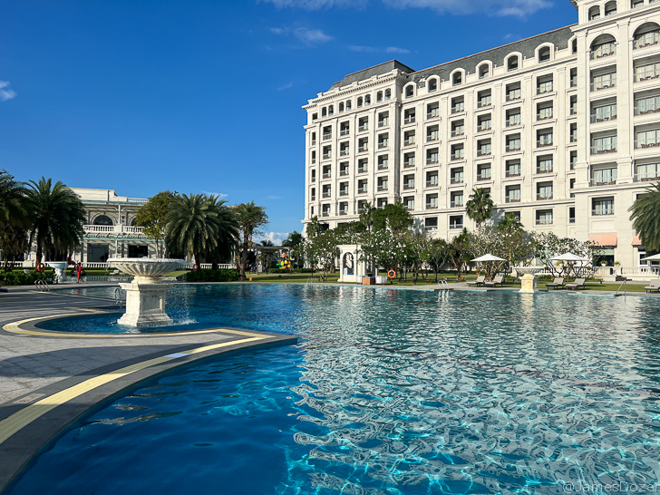 a pool with a fountain in front of a building
