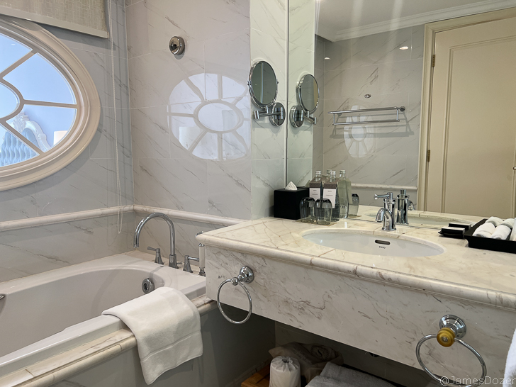 a bathroom with marble countertop sink and tub