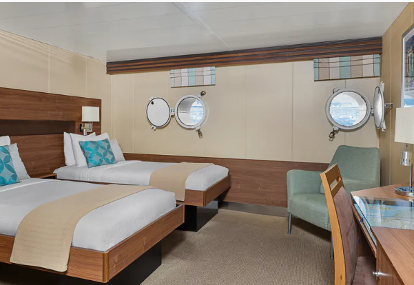 a room with two beds and a chair