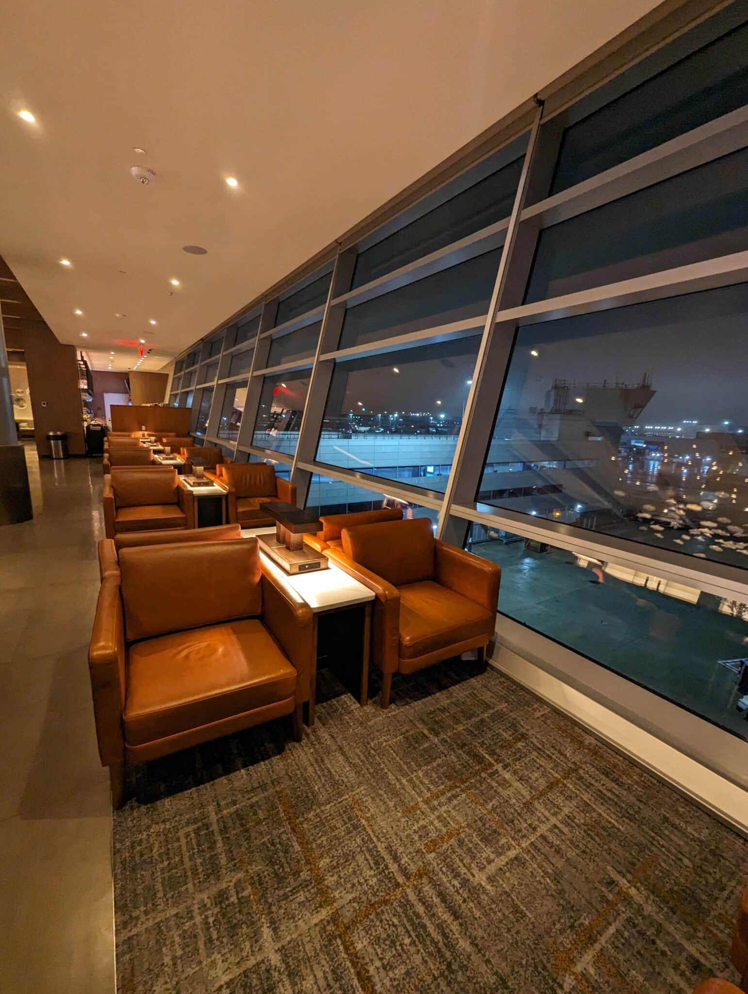 a room with chairs and tables and a large window