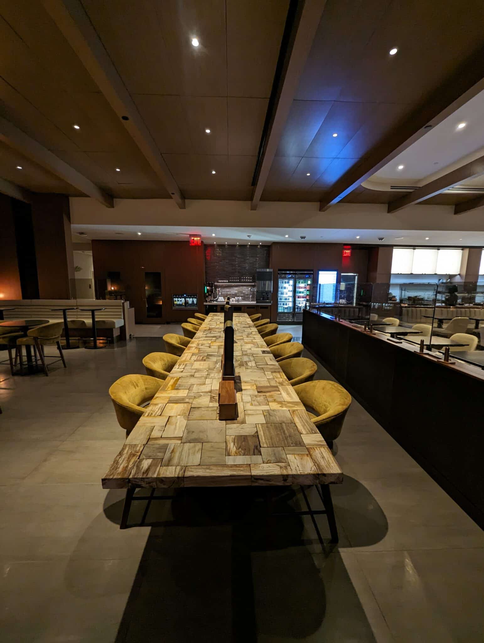 a long table with chairs in a room with a bar and a counter