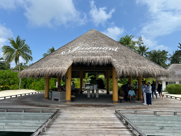 a group of people standing under a thatched roof