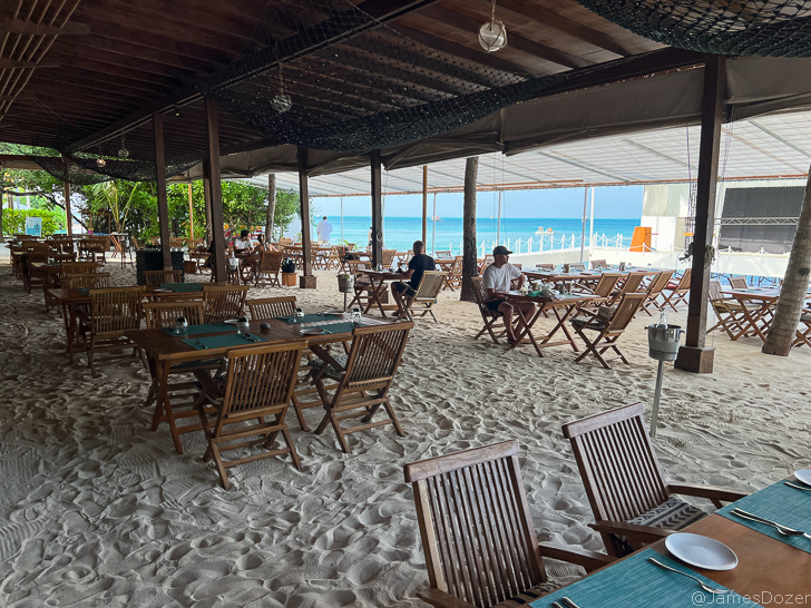 a restaurant with tables and chairs on the beach