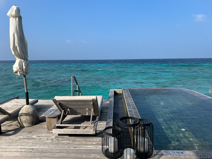 a pool with a chair and a statue on it