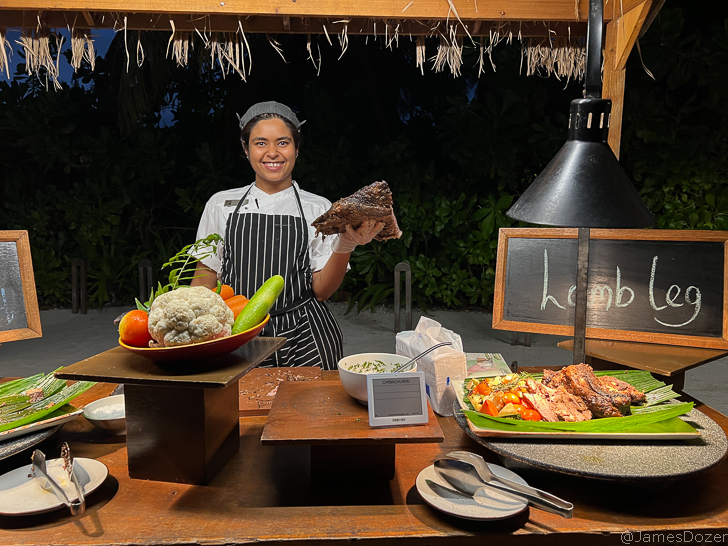 a woman standing behind a table with food
