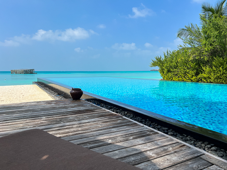 a pool with a wooden deck and a wooden table