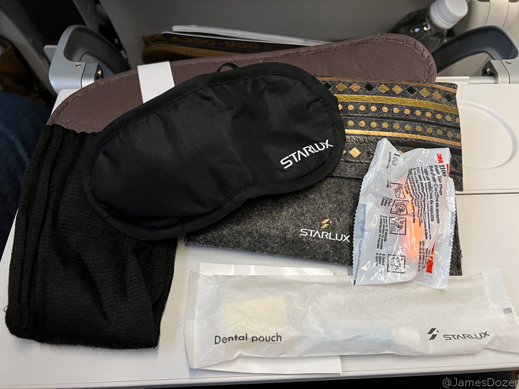 a black eye mask and a black hat on a table