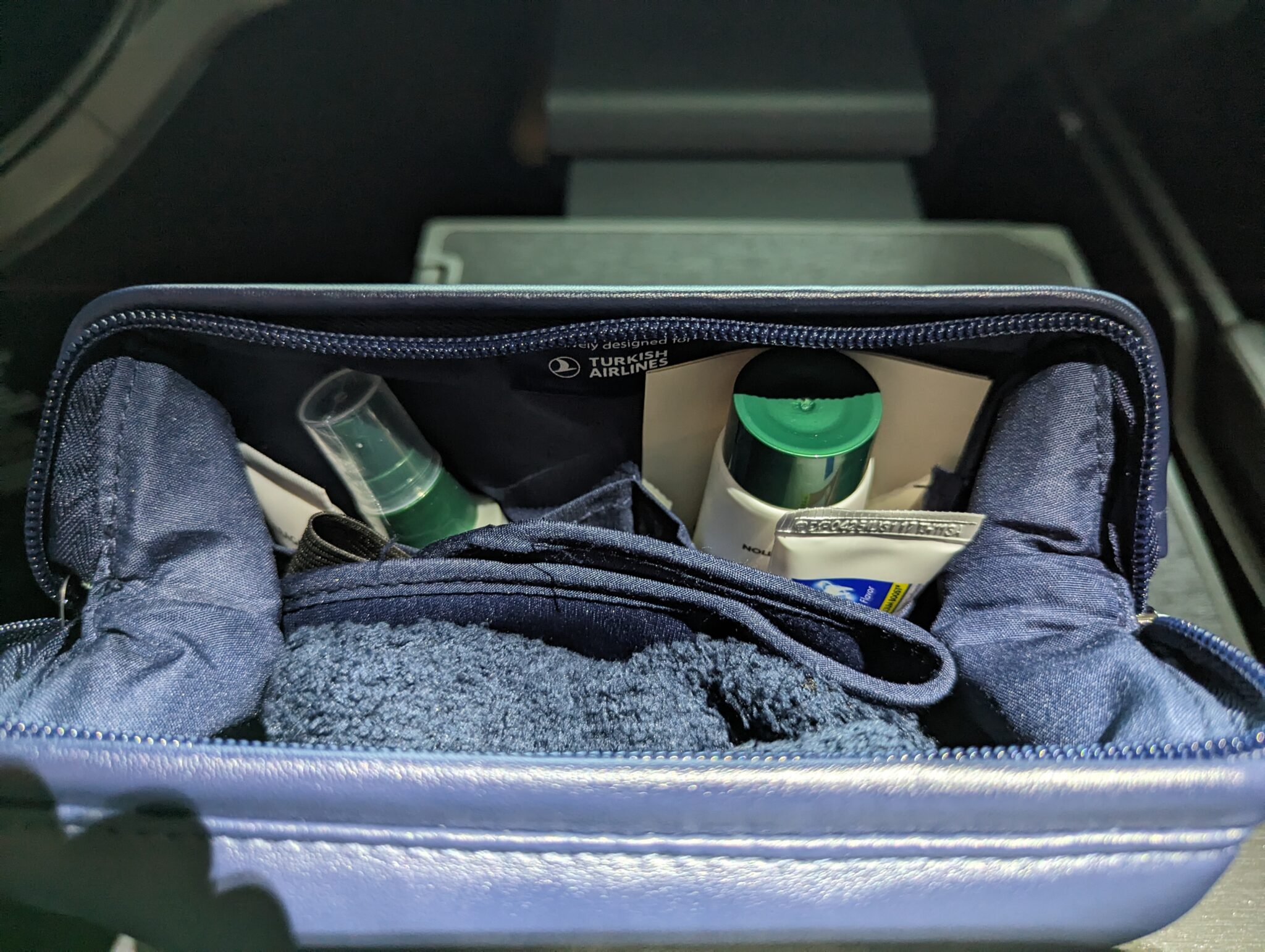 a blue bag with a towel and toiletries inside