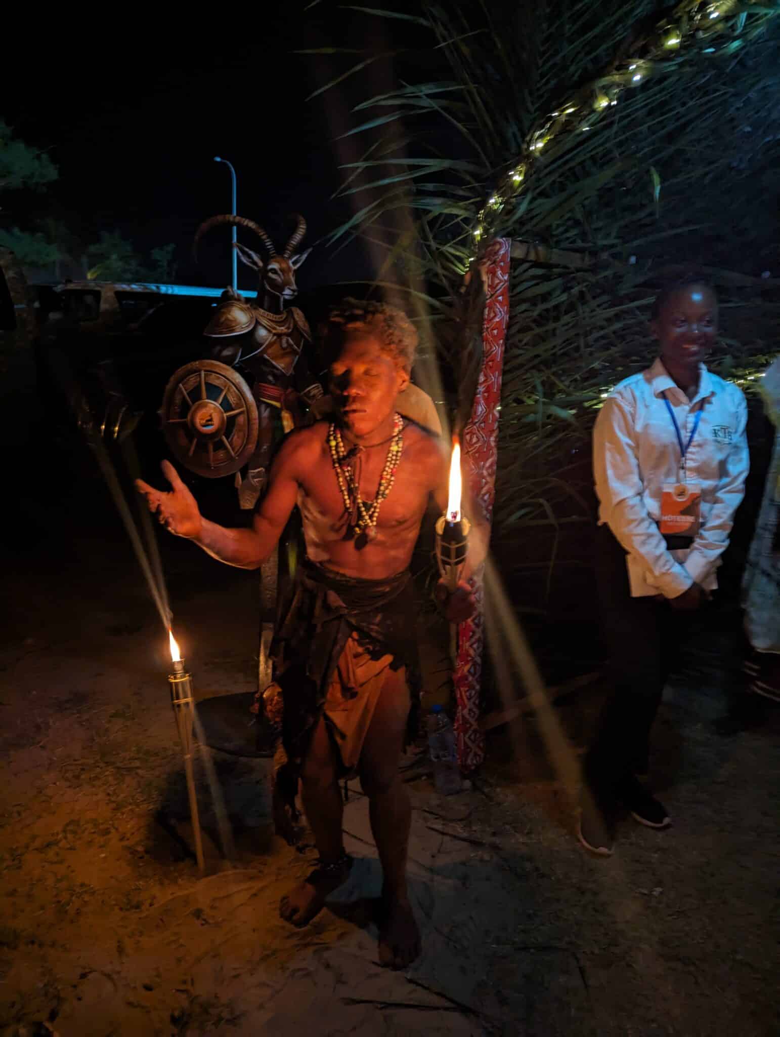 a man holding a torch with a person standing next to a person standing