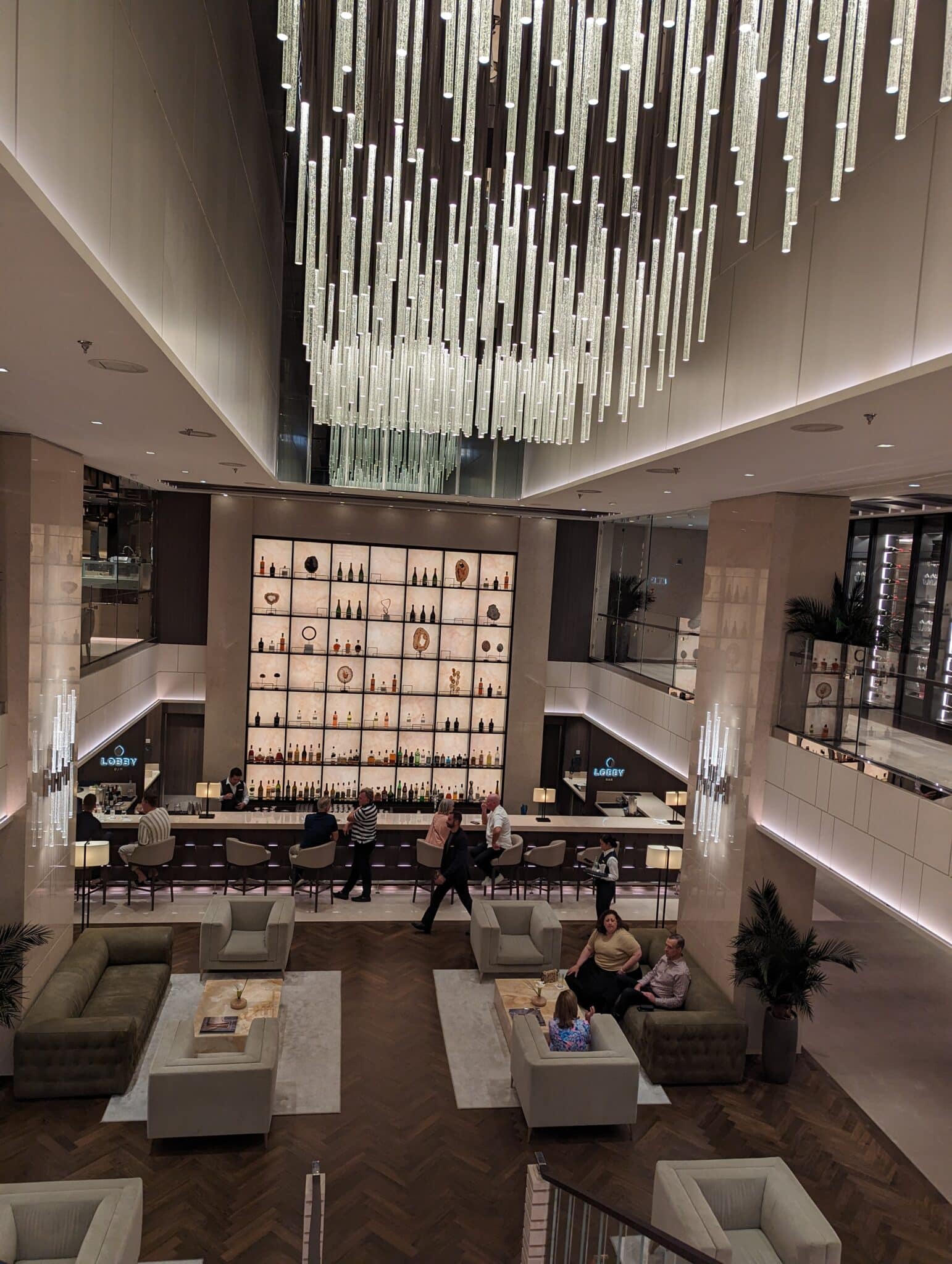 a group of people sitting in a room with a chandelier