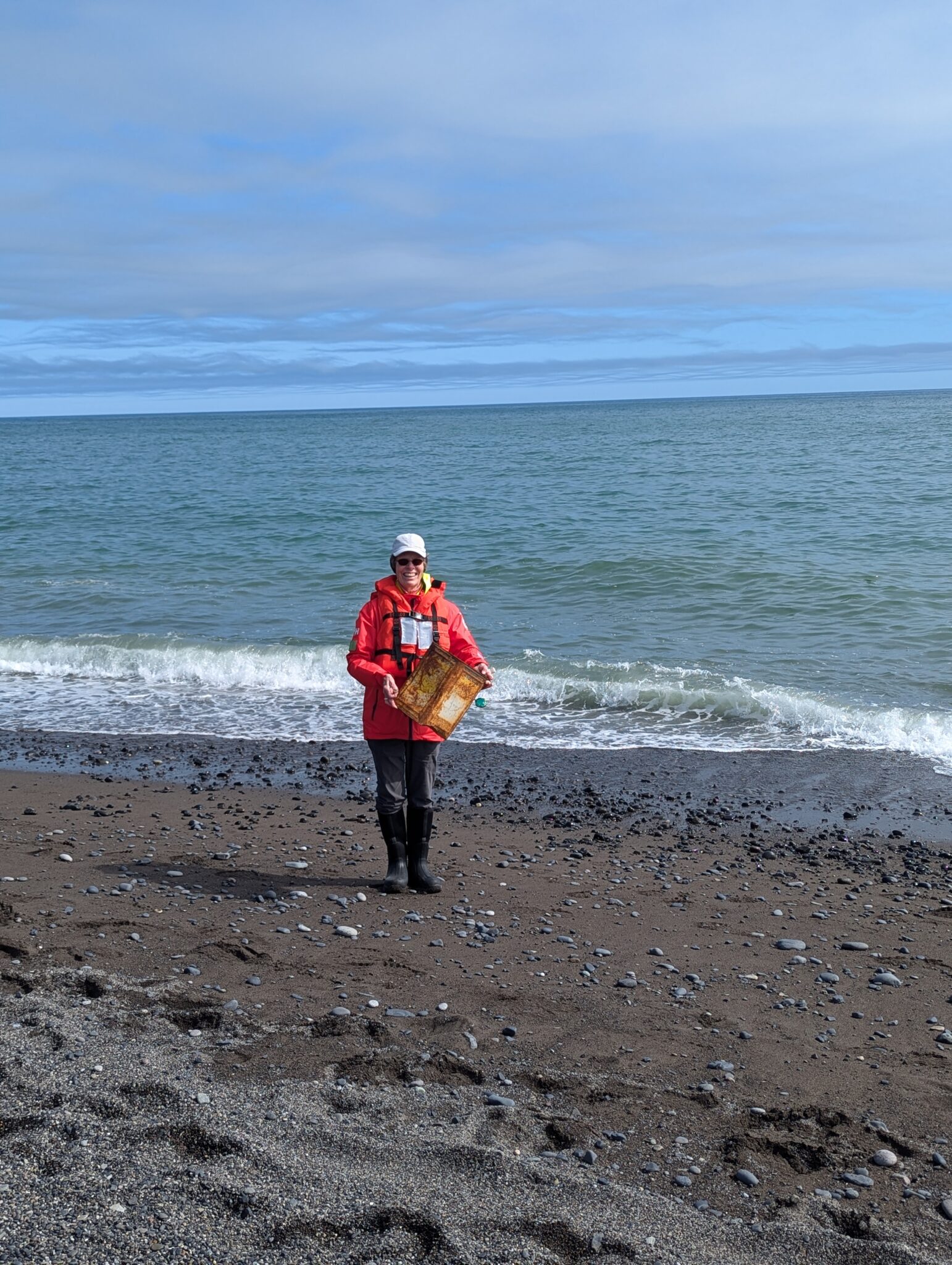 a woman in a red jacket on a beach