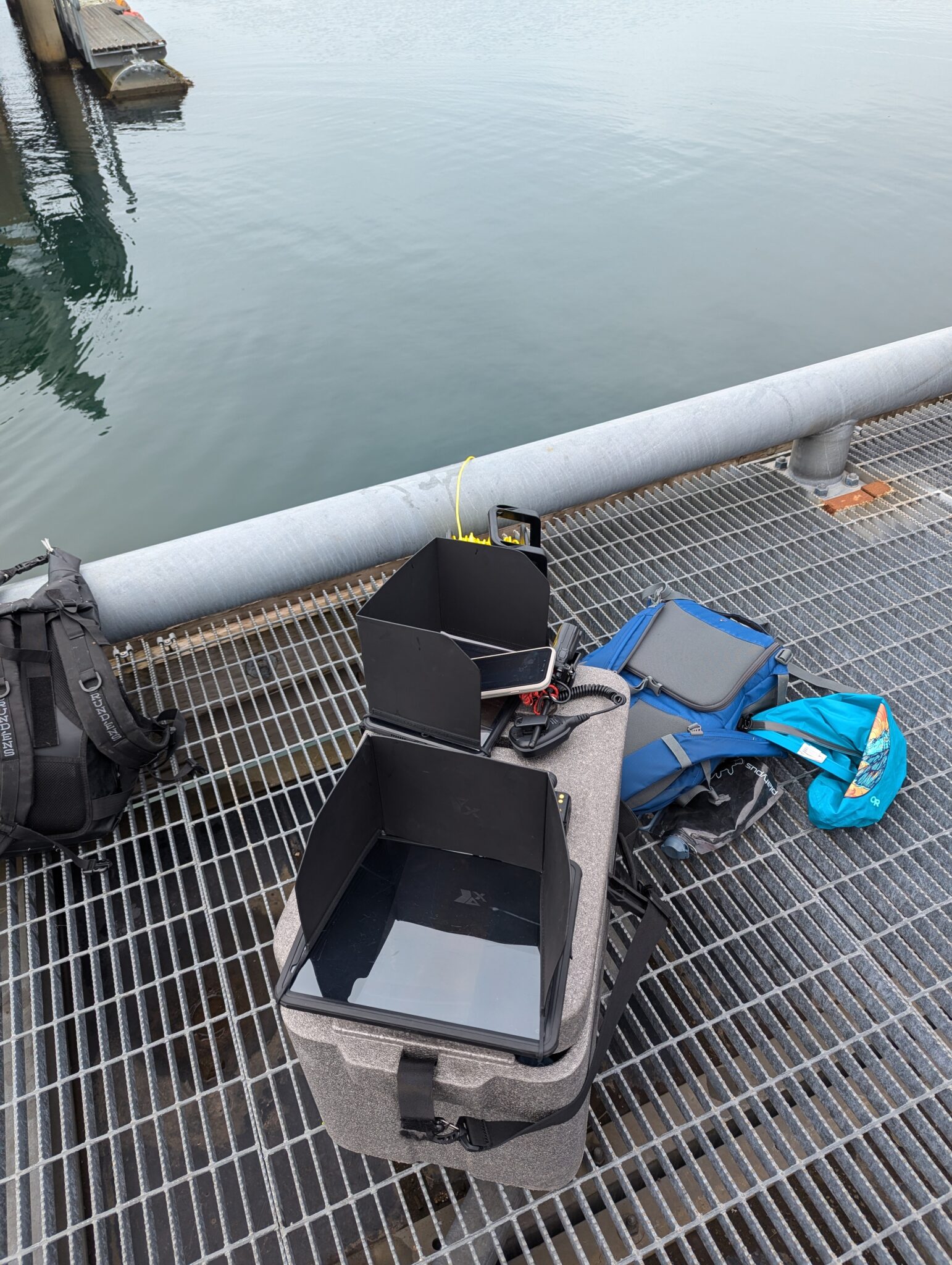 a backpacks and a box on a metal grate