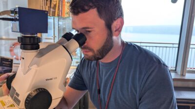 a man looking through a microscope