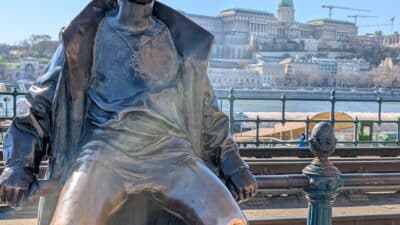 a statue of a boy sitting on a rail