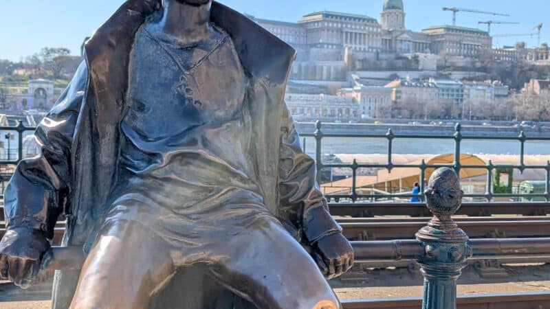 a statue of a boy sitting on a rail
