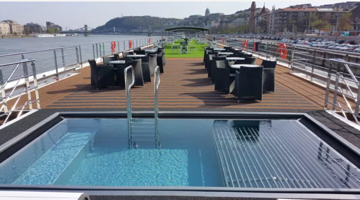 a pool with tables and chairs on a dock