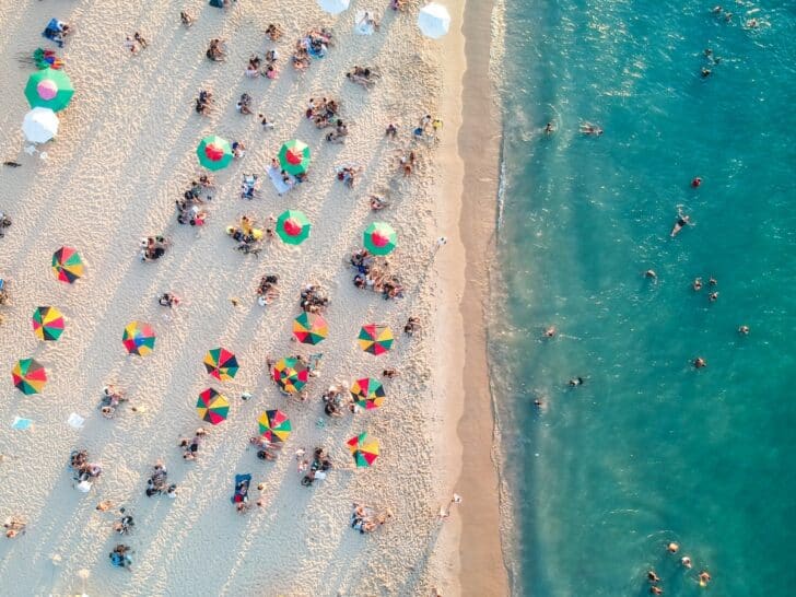 a group of people on a beach with umbrellas
