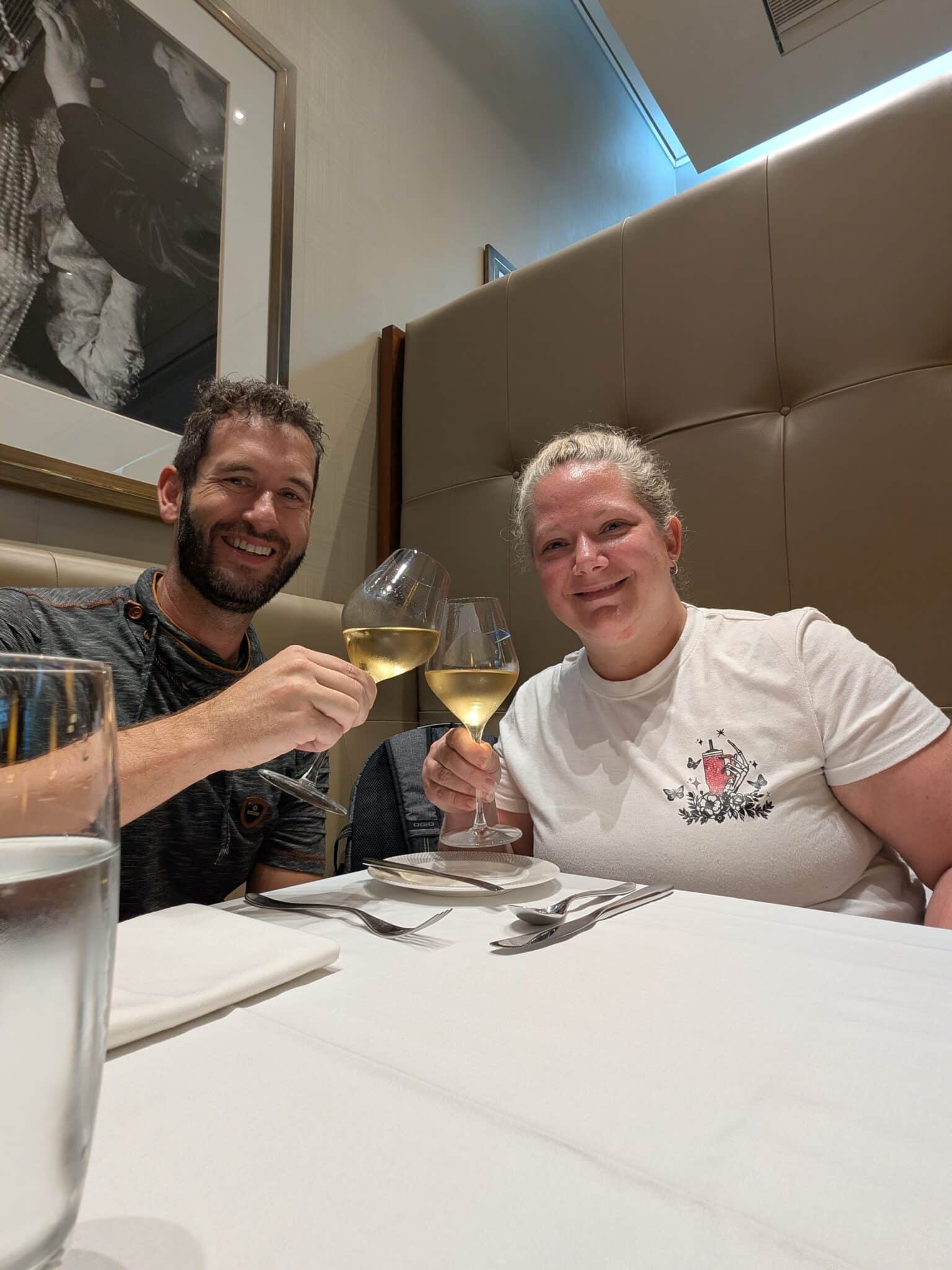 a man and woman sitting at a table with wine glasses