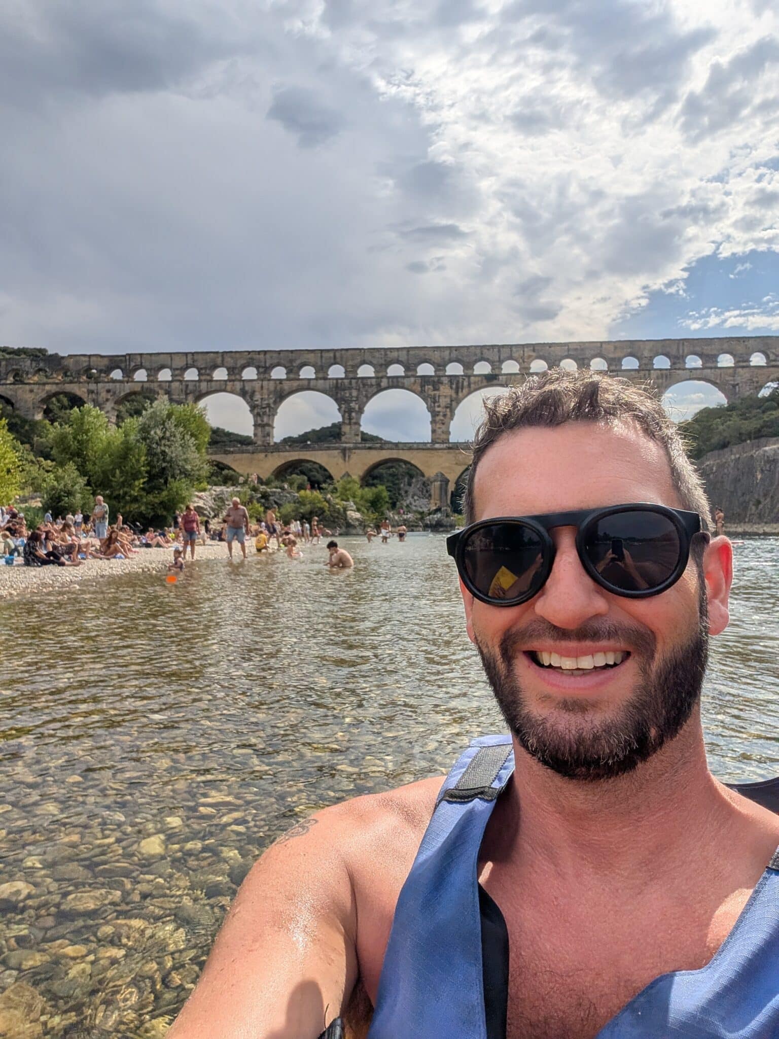 a man taking a selfie in front of a bridge