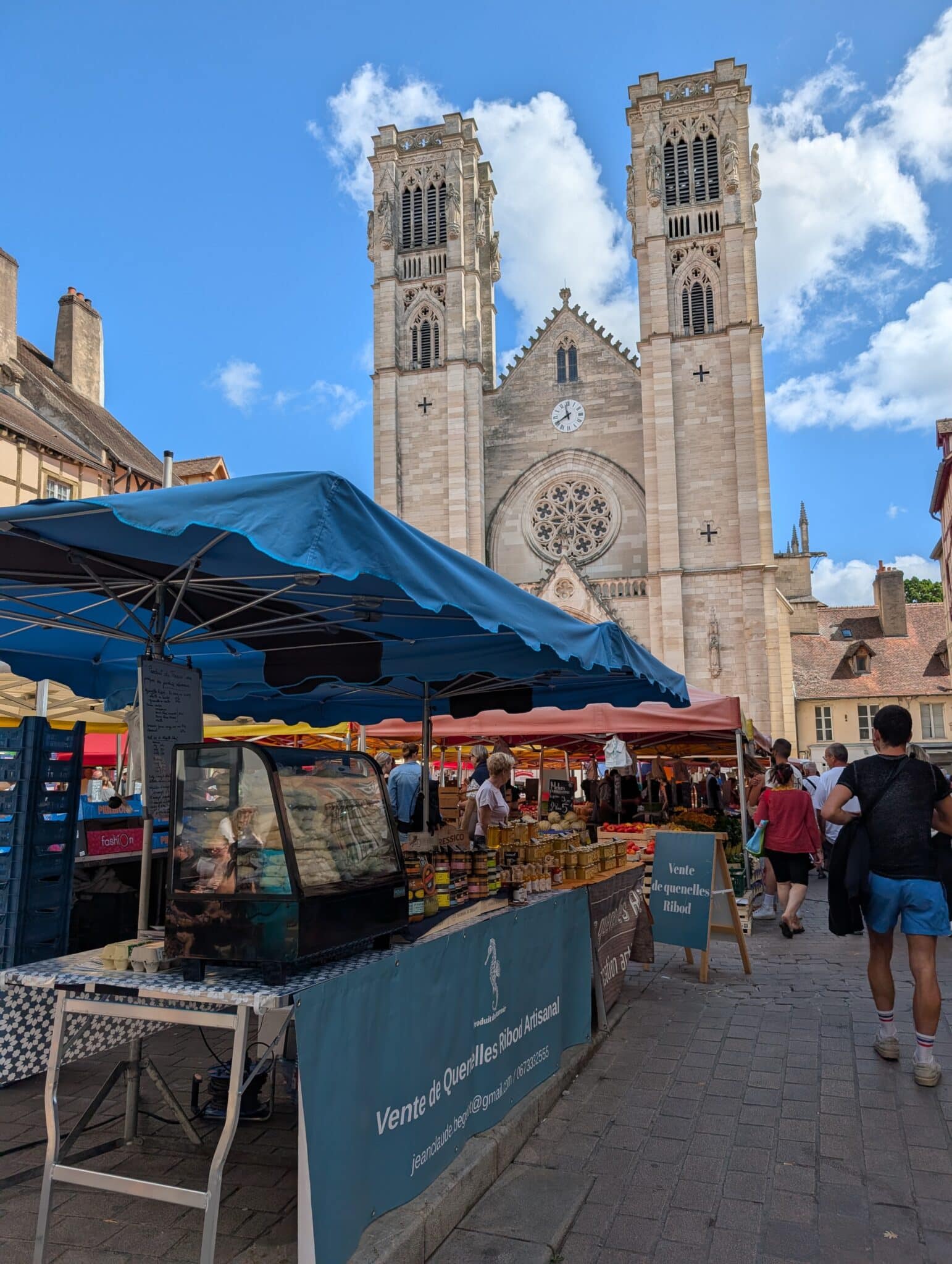 a street market with a large building and a clock tower
