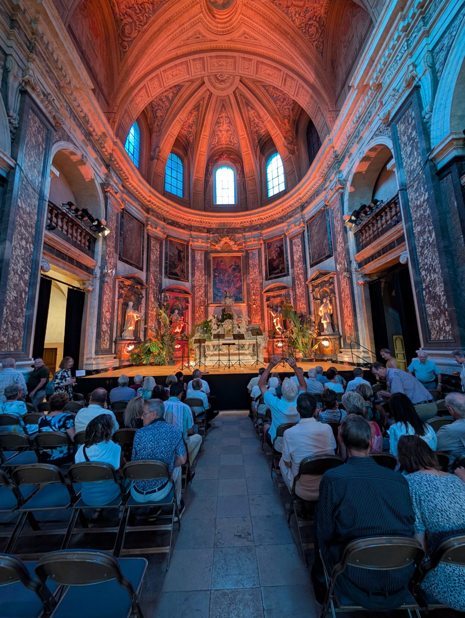 a group of people sitting in chairs in a room with a dome ceiling