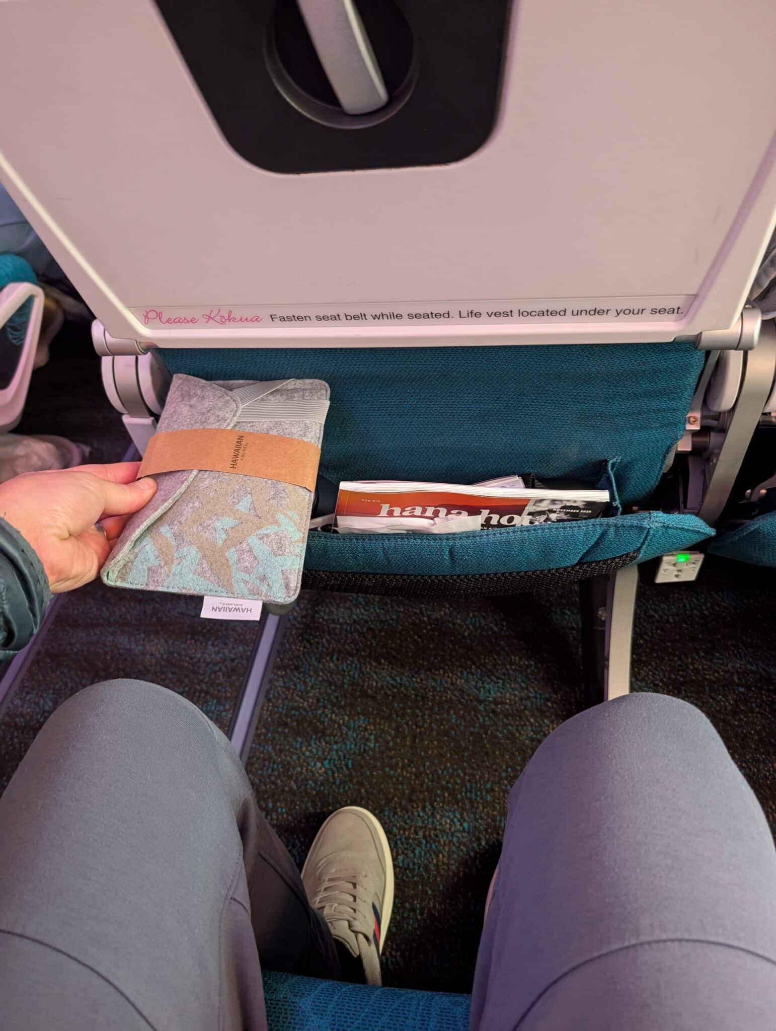 a person holding a wallet in the seat of an airplane