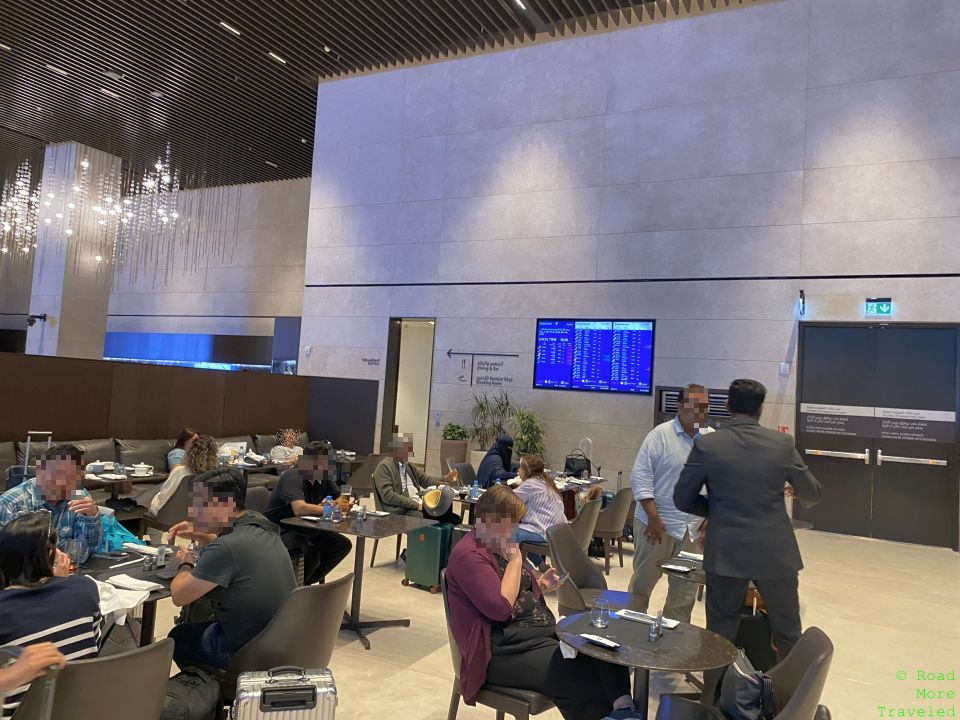 people sitting at tables in a room with people in the background