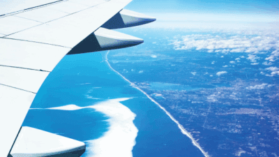 an airplane wing and land and water