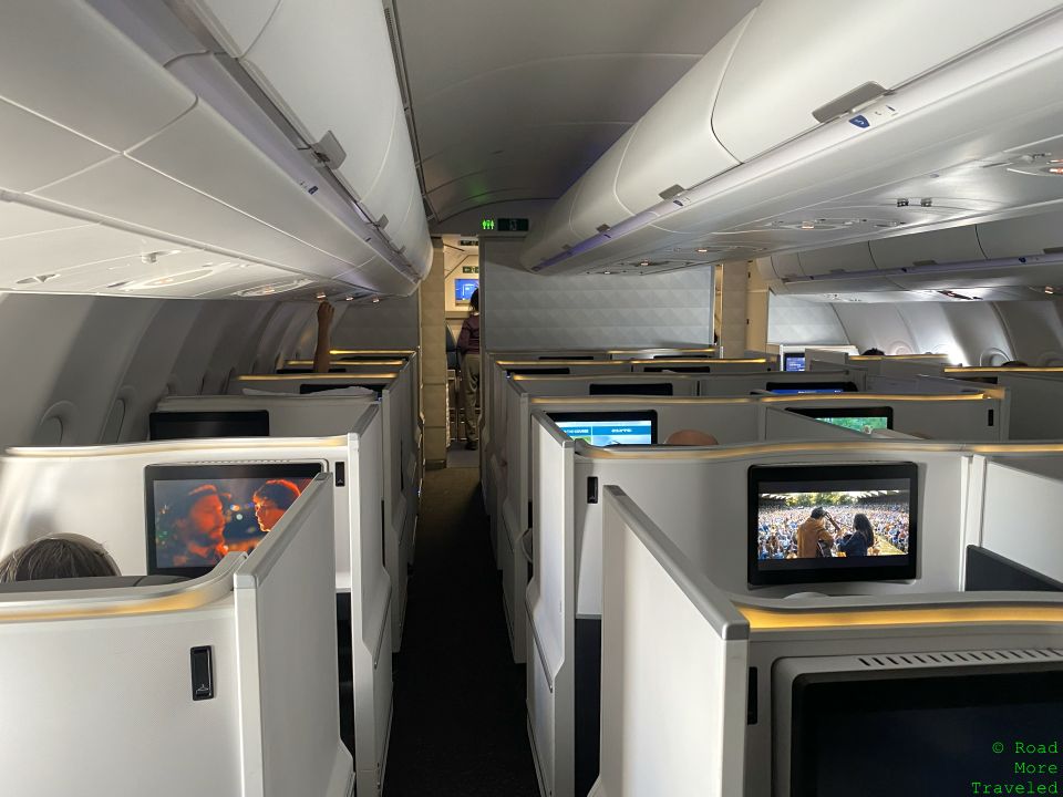 a row of white cubicles with televisions on the side