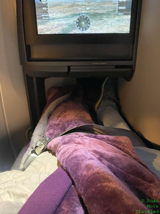 a person lying in a bed with a tv